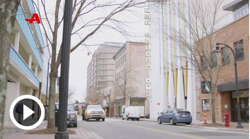 city street with a few cars surrounded by buildings